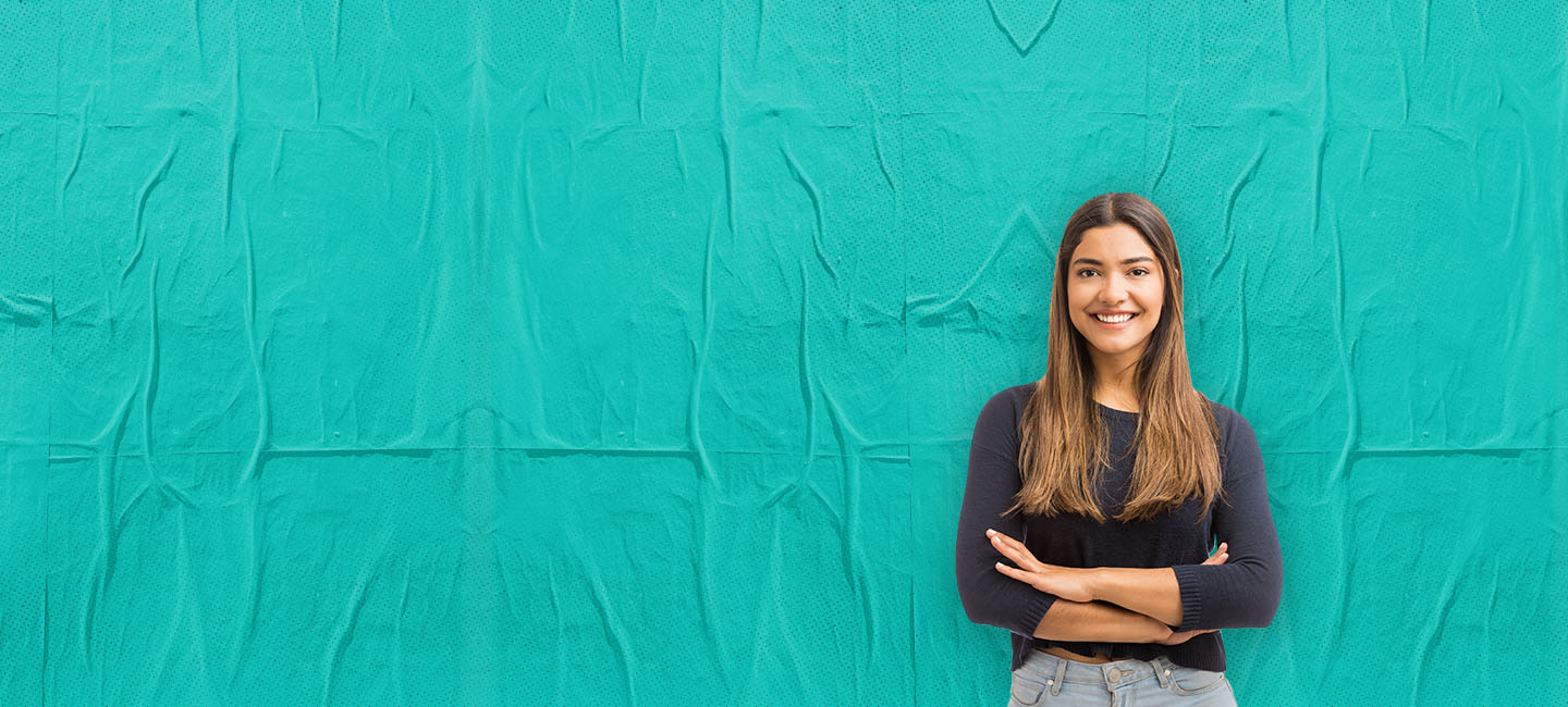 jovem rapariga loira , com camisola preta e jeans  sobre fundo verde