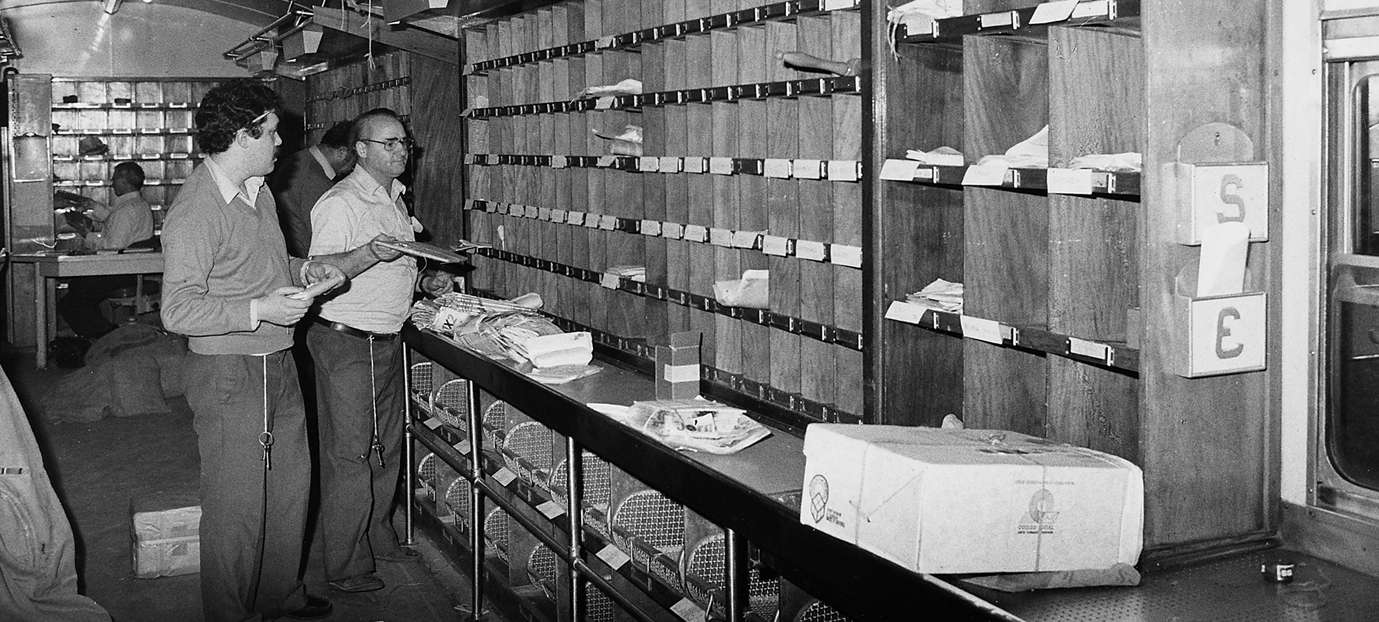 Carteiros a dividirem correio nos antigos Centro de Distribuição Postal.