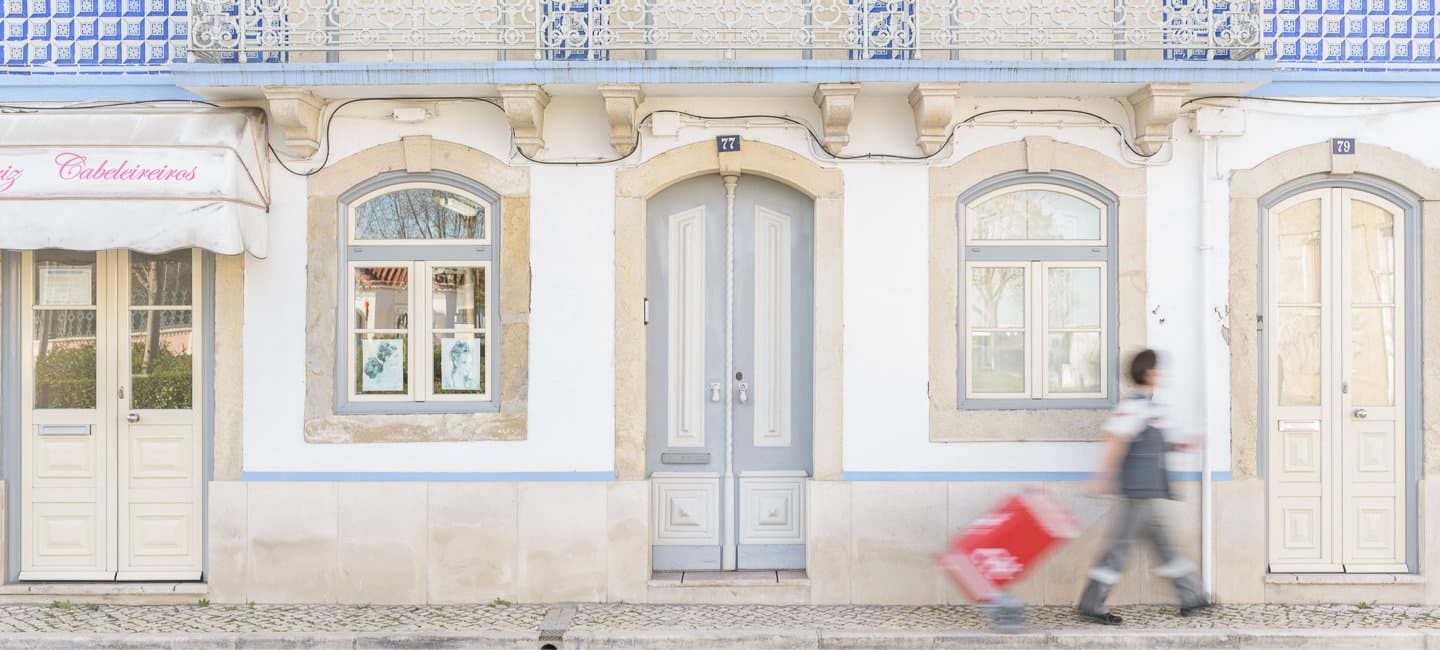 Carteiro a entregar correspondências num bairro